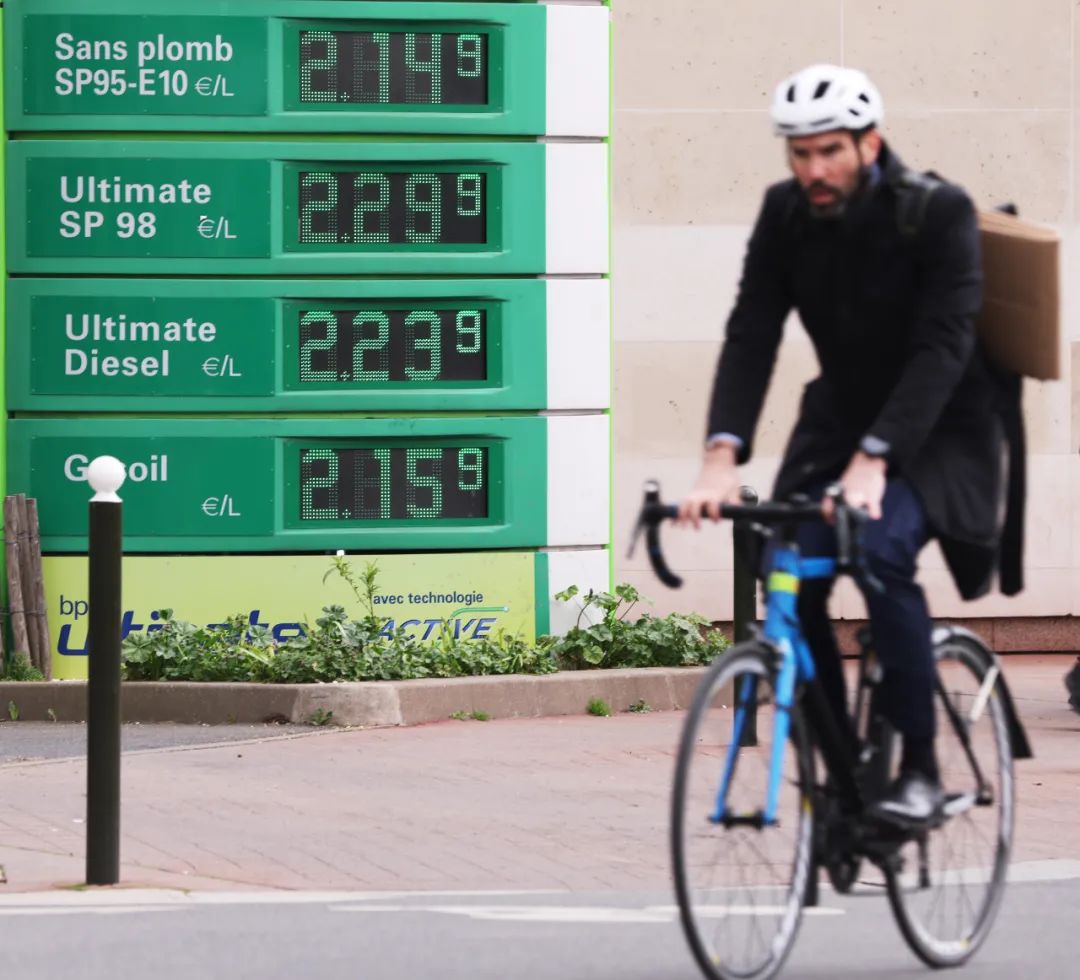 一名男子骑车经过法国巴黎一处加油站。新华社记者高静摄