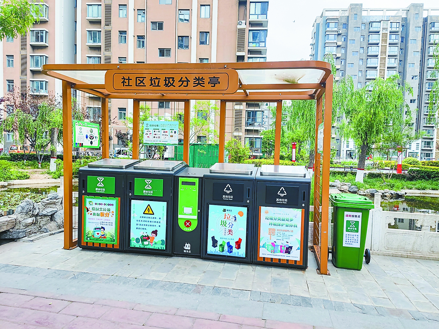 图为小区内增设的智能分类误时投放专用垃圾桶.