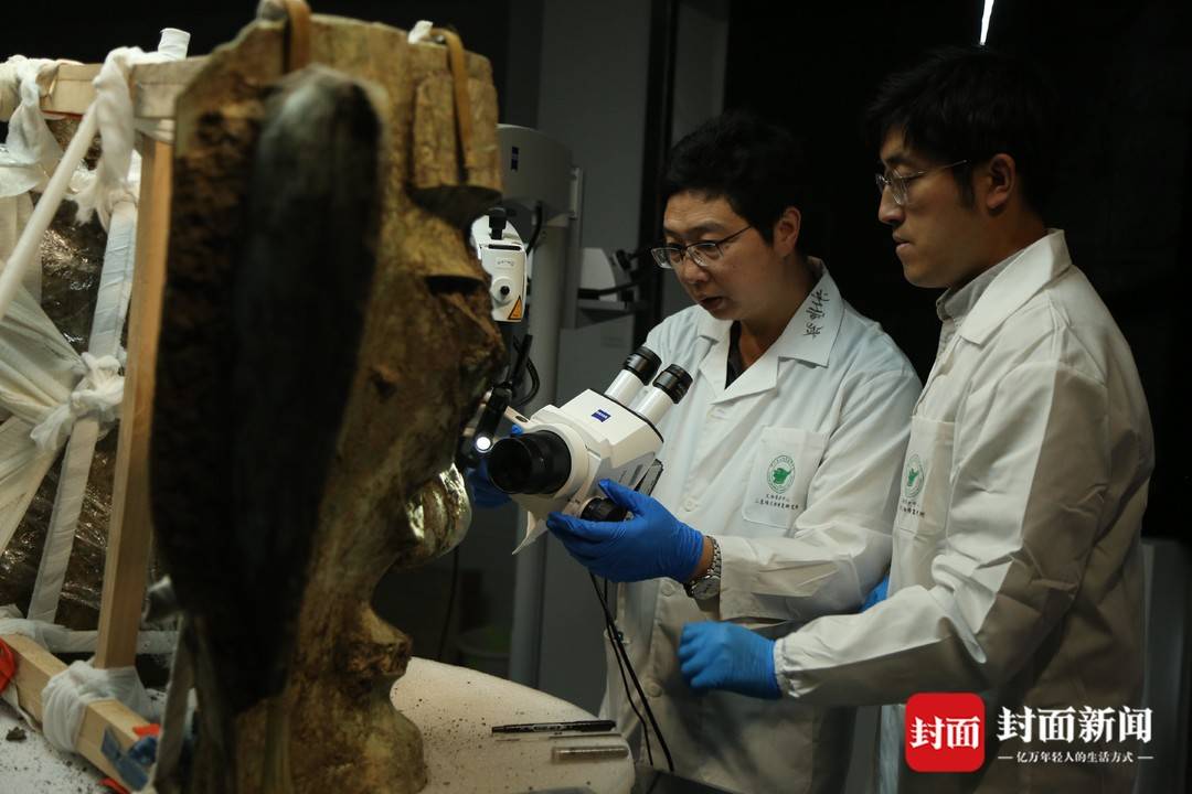 文保专家对青铜大面具进行清理检测(四川省文物考古研究院供图)