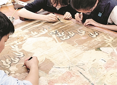 图为国家图书馆古籍修复人员在修复水陆画（资料图片）。 新华社发
