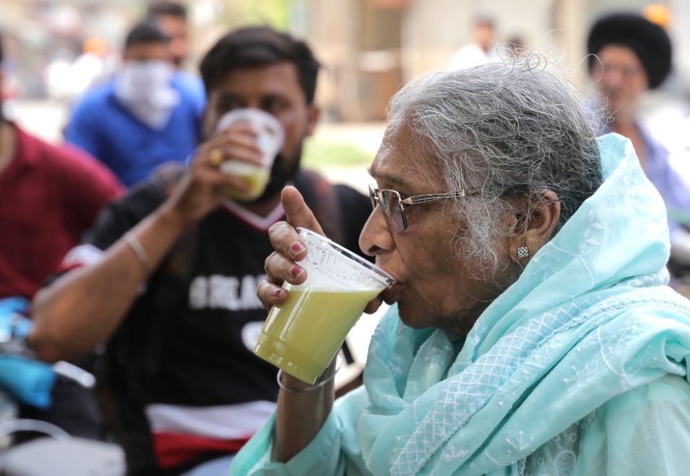 4月29日，在印度阿姆利则，人们喝冷饮消暑 图片开端：新华社