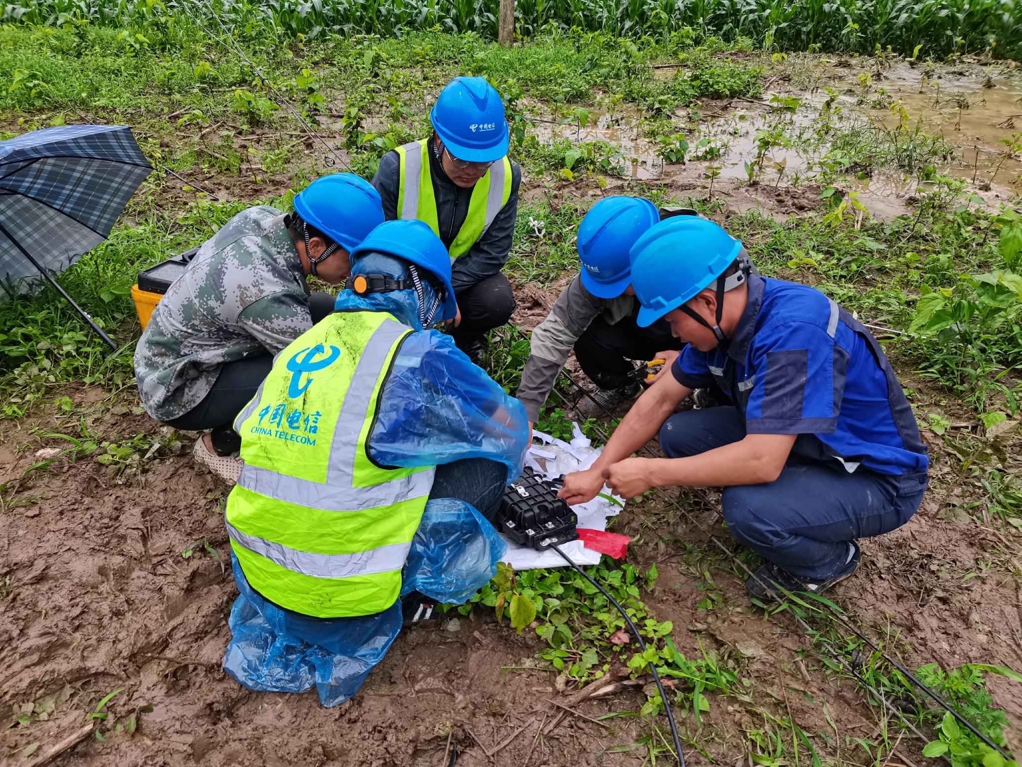 图为抢修队员在抢修受损光缆.