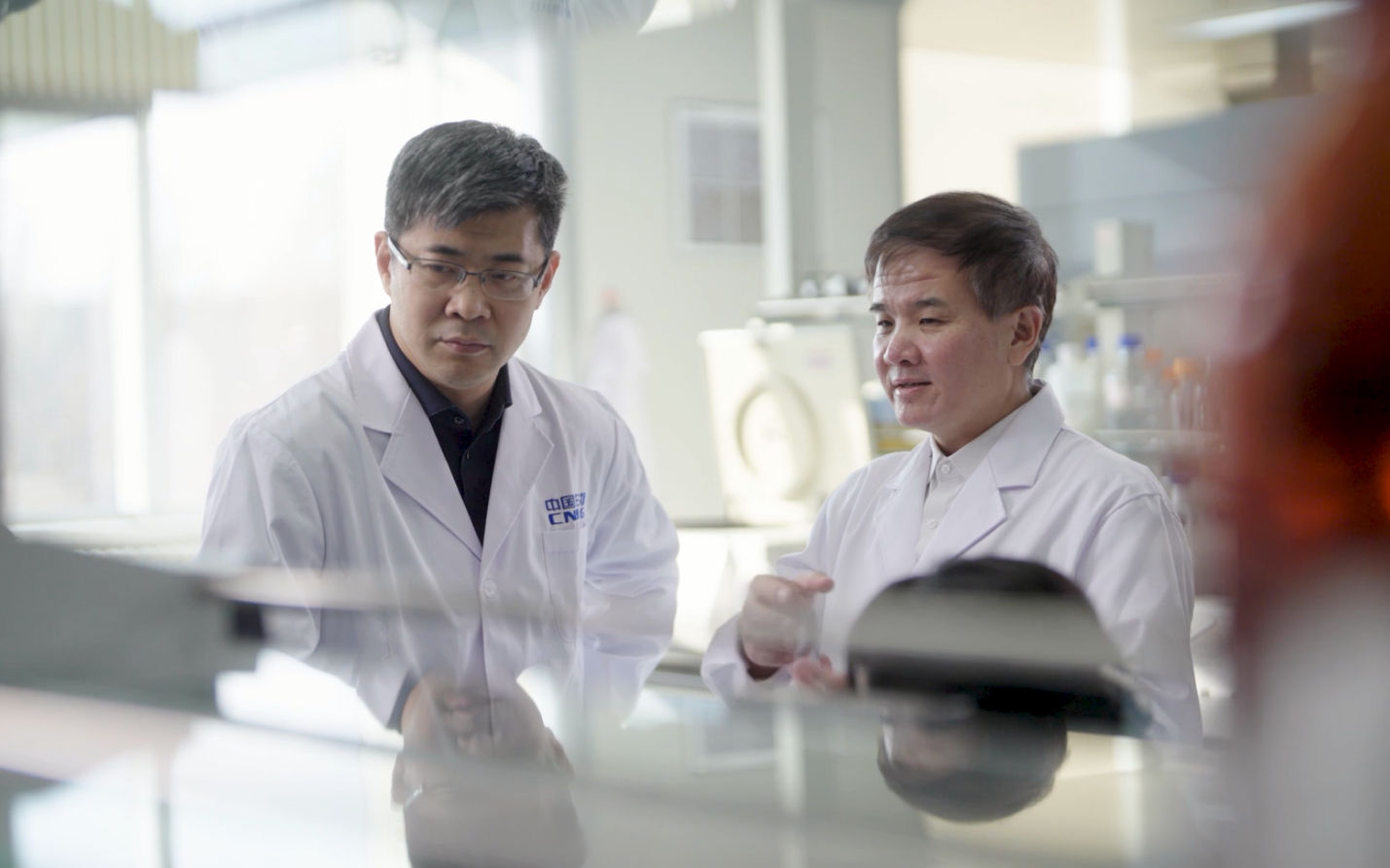 张云涛(右)在实验室与工作人员讨论研发方案.中国生物供图