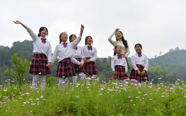 在分宜县洞村乡,老师钟琳珊(右二)带着合唱团的孩子们在户外歌唱(5月