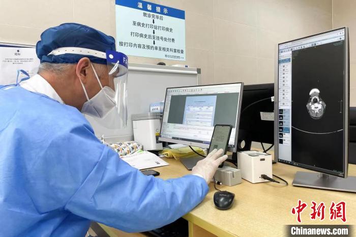 头颈部肿瘤多学科首席专家嵇庆海教授，仔细查阅互联网医院挂其专家号患者的一位病史和影像资料。朱一齐 摄