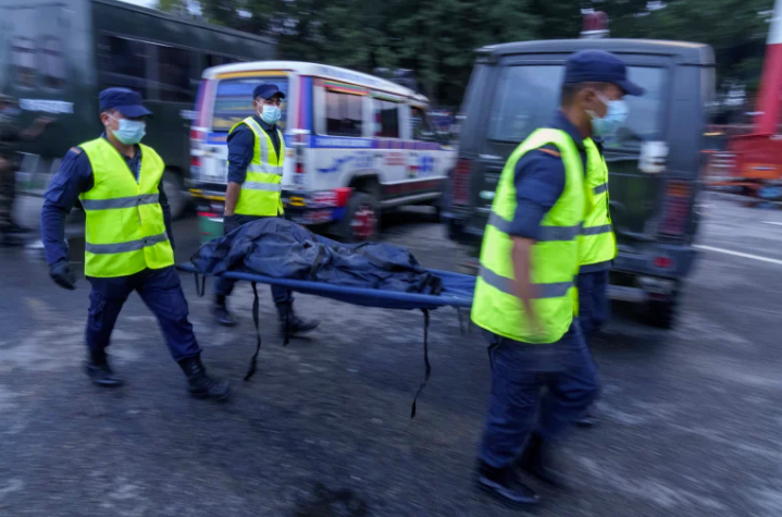 Rescue workers transport bodies of victims (Al Jazeera)
