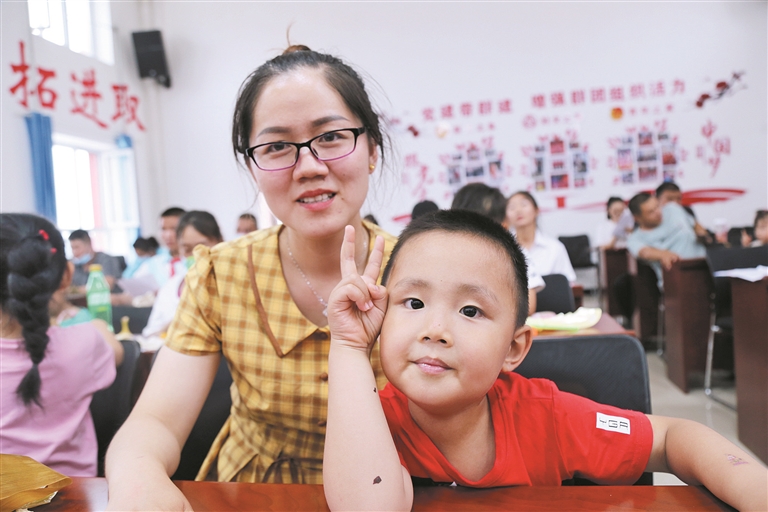 5月26日，五师八十一团幼儿园里，家长郑慧云陪儿子参加亲子游戏。 杨姗姗 摄
