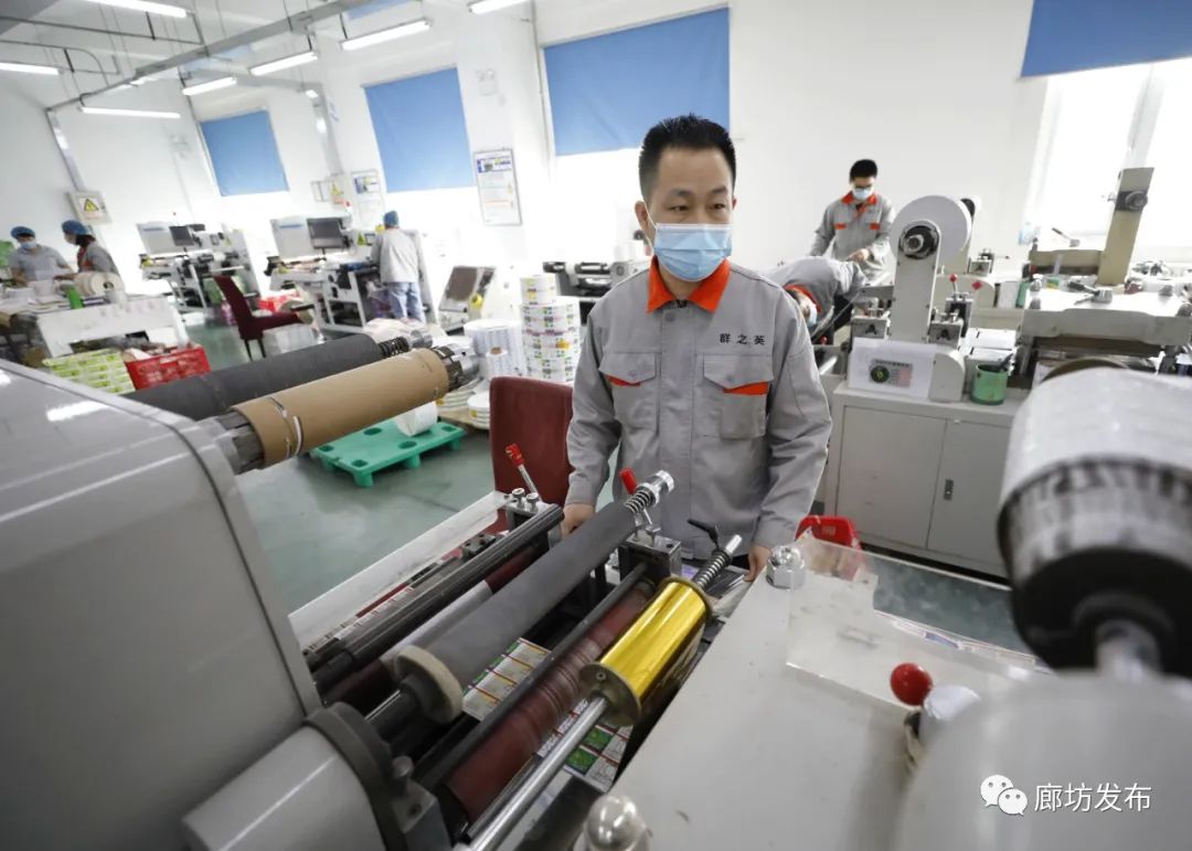 图为在固安县工业园一印刷公司生产车间,工作人员对印刷品进行不干胶