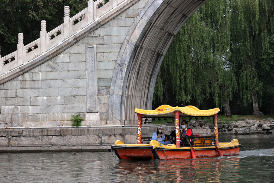 6月3日，游客在颐和园玉带桥下泛舟赏景。中国日报记者 姜东 摄