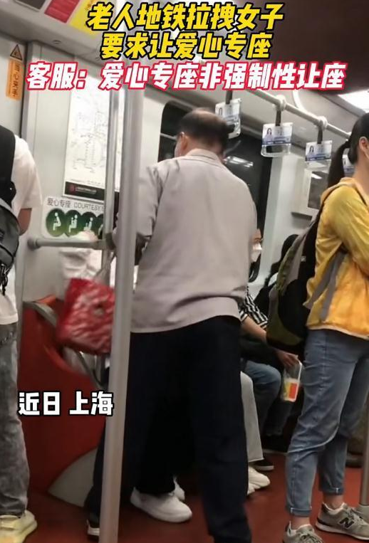 老人在地铁上拉拽年轻女子要求让爱心专座，男乘客解围：别争了，来坐这里