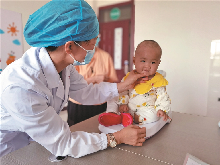 5月30日，二师焉耆医院儿保科工作人员魏玉萍在为幼儿做常规身体检查。 周华丽 摄
