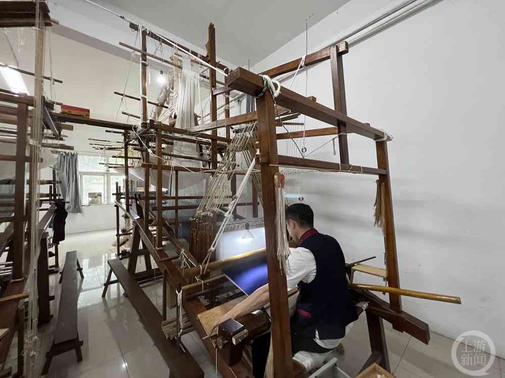 ▲织锦工人正在制作旗袍所需要的提花锦缎。图片来源/上游新闻记者时婷婷