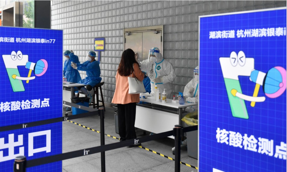 4月30日,在杭州市上城区湖滨街道一处核酸采样点,医护人员为市民进行