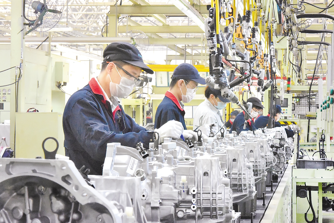 唐山爱信齿轮有限责任公司工人在变速器生产线上进行组装工作.