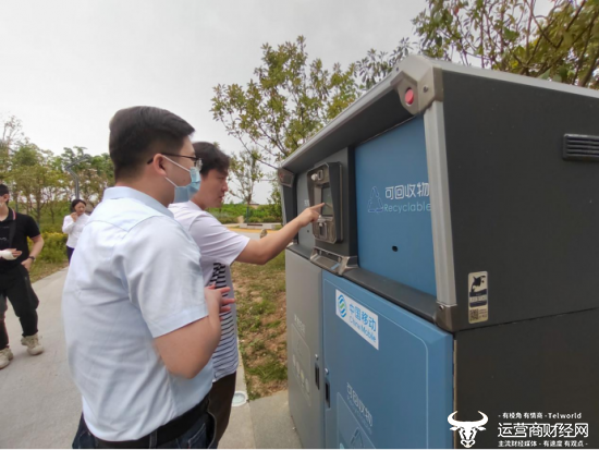 （图注：市民正在使用襄州区民发广场上湖北移动投运的一台5G智能垃圾箱）