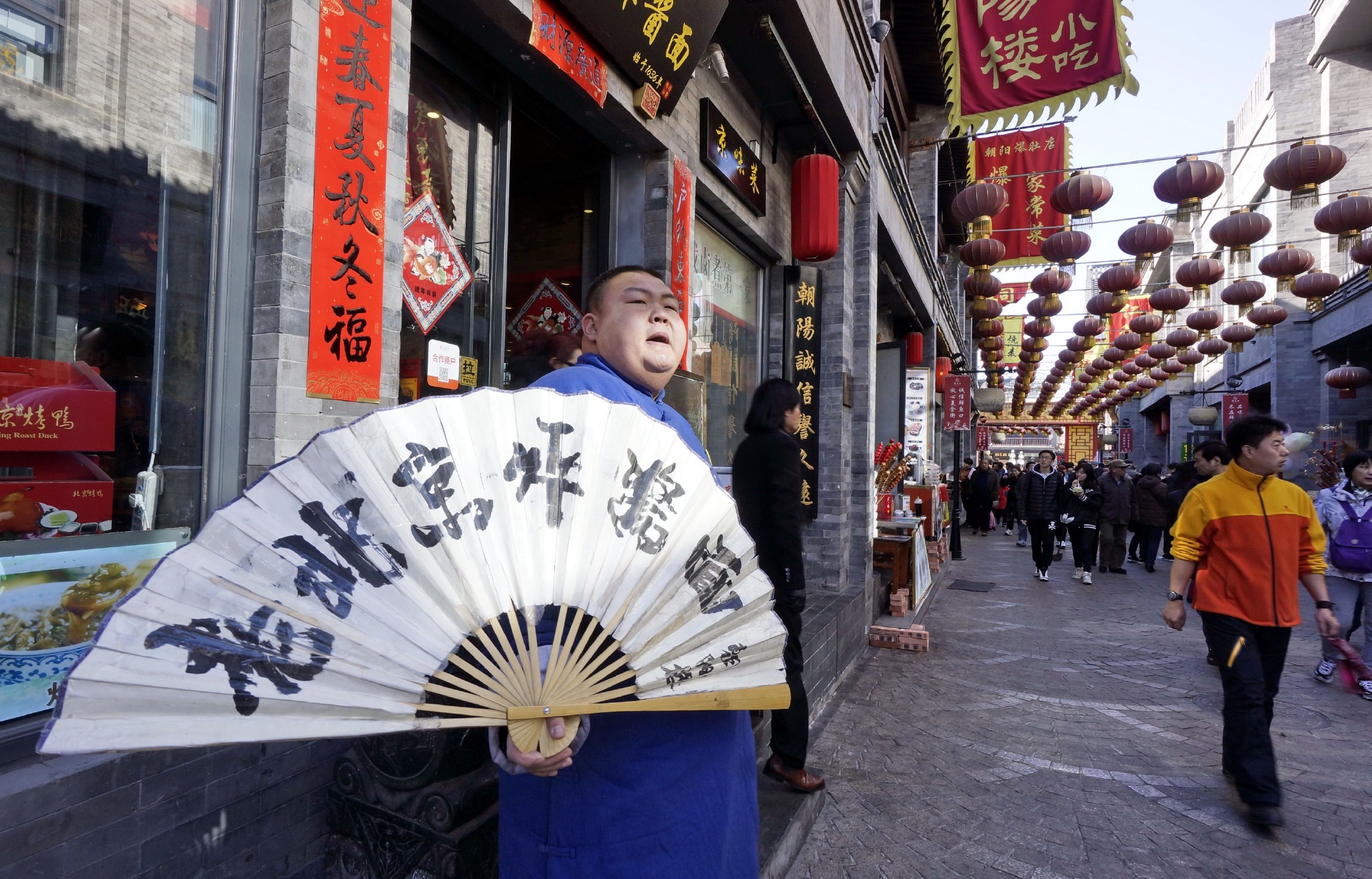 北京前门大街一家老字号的工作人员在门口迎客(2017年2月5日摄).
