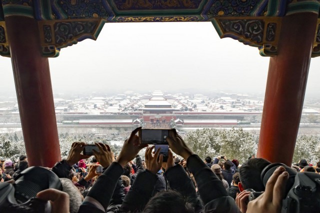 人们在北京景山公园的万春亭拍摄雪后的故宫（2019年11月30日摄）。新华社记者 沈伯韩 摄