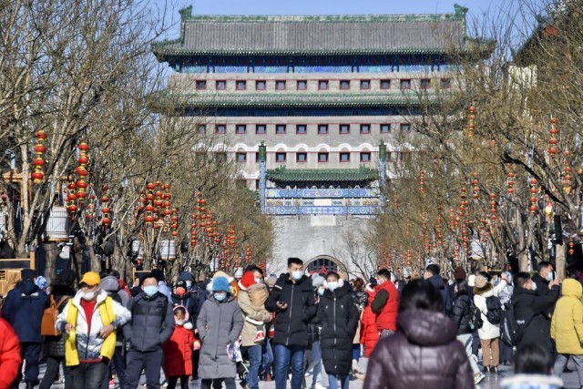 游人在北京前门大街游览，身后是正阳门箭楼（2月4日摄）。 新华社记者 李欣 摄