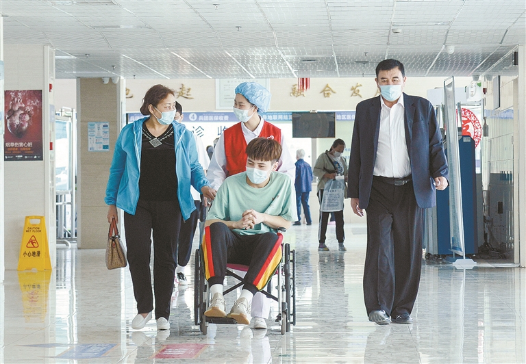 在十师北屯医院，医护人员帮助来自福海县的患者就诊（资料图片）。兵团日报全媒体记者 陈洋 摄