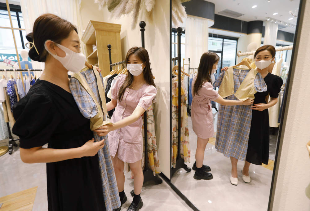 6月6日在永定城·京津冀固安国际商贸城,一名店员向顾客介绍服装.