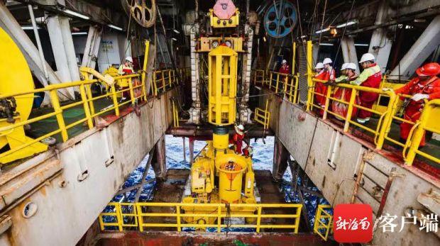 国产深水水下采油树在月池就位，工程师们正在安装采油树保护框架导向桩。通讯员供图