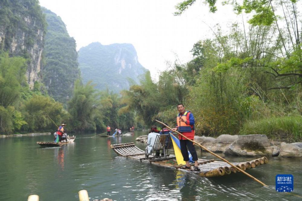 筏工在广西桂林阳朔县境内的漓江支流遇龙河上撑竹筏（4月12日摄）。新华社记者 周华 摄