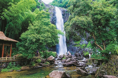 昨天,在宁海县梅林街道雁苍山风景区的九龙飞瀑景点,不少游客或在浅水