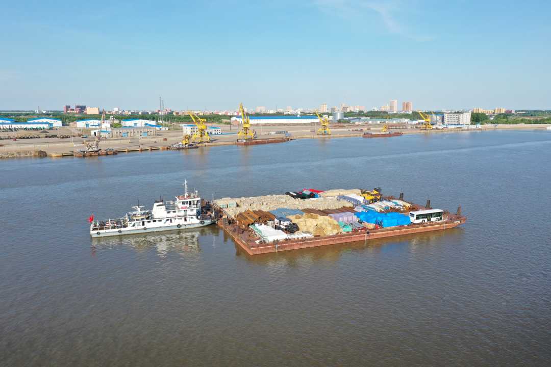 满载出口货物的驳船驶离同江口岸西港水运码头.陈一妹摄