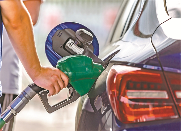 6月14日,工作人员在筑大高速黔西服务区中石化加油站为顾客加油.