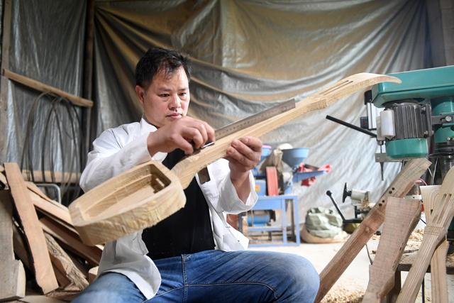 在广西三江侗族自治县林溪镇冠洞村,杨龚在工作间内制作侗族琵琶