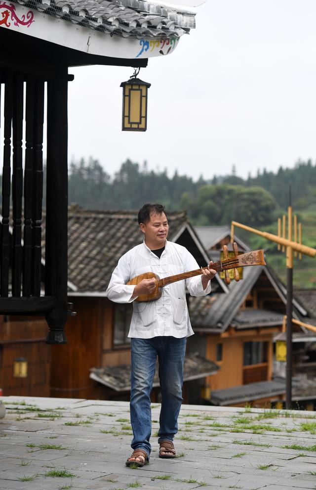 6月15日,在广西三江侗族自治县林溪镇冠洞村,杨龚在弹唱侗族琵琶歌.