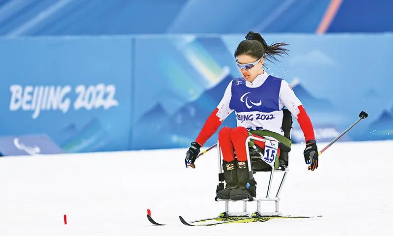 在北京冬残奥会上，中国代表团运动员全项参赛、勇于超越，自强不息、团结拼搏，奏响了坚韧不屈、乐观进取的生命凯歌，不仅体现出残疾人的体育精神与实力，更体现出中国人权保障与国家发展的成绩。图为2022年3月9日，中国代表团运动员杨洪琼在残奥越野滑雪女子短距离（坐姿组）比赛中。 新华社记者 杨冠宇/摄