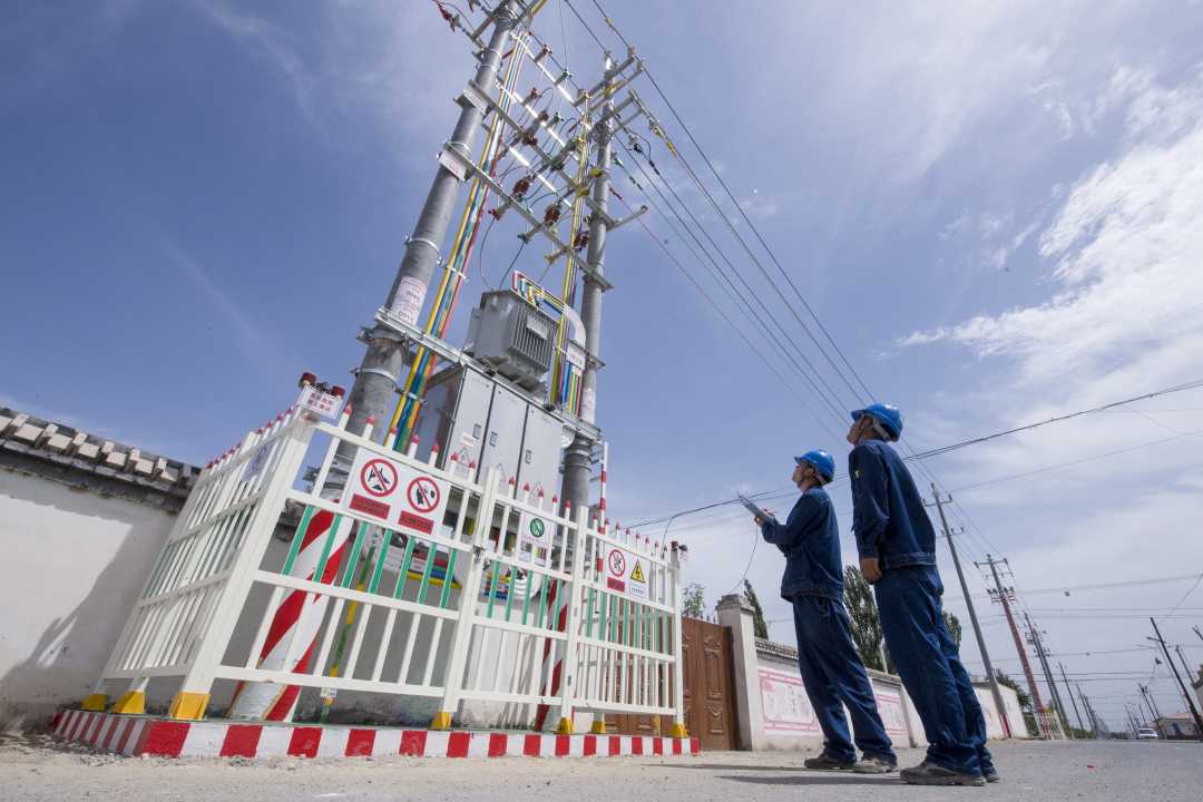 图为电网运维人员检查指挥台区运行情况.周广科摄