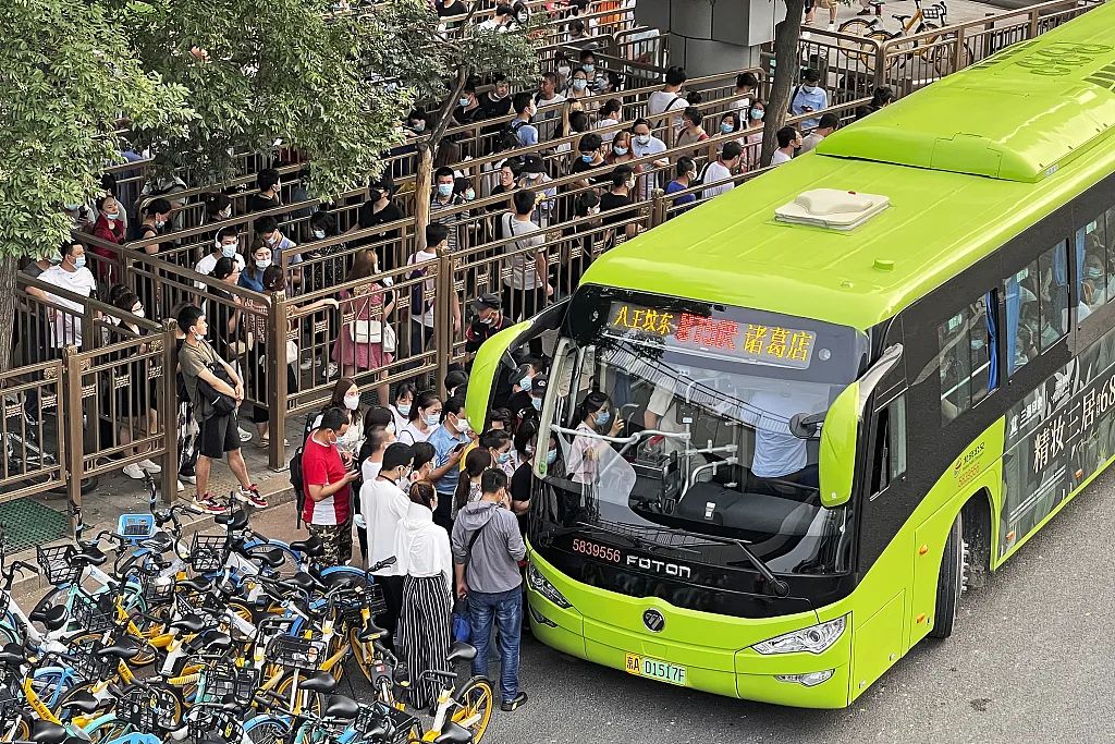2021年7月16日，北京八王坟公交站，晚高峰上班族排队乘坐开往燕郊的通勤远郊公交车815路。（图|视觉中国）