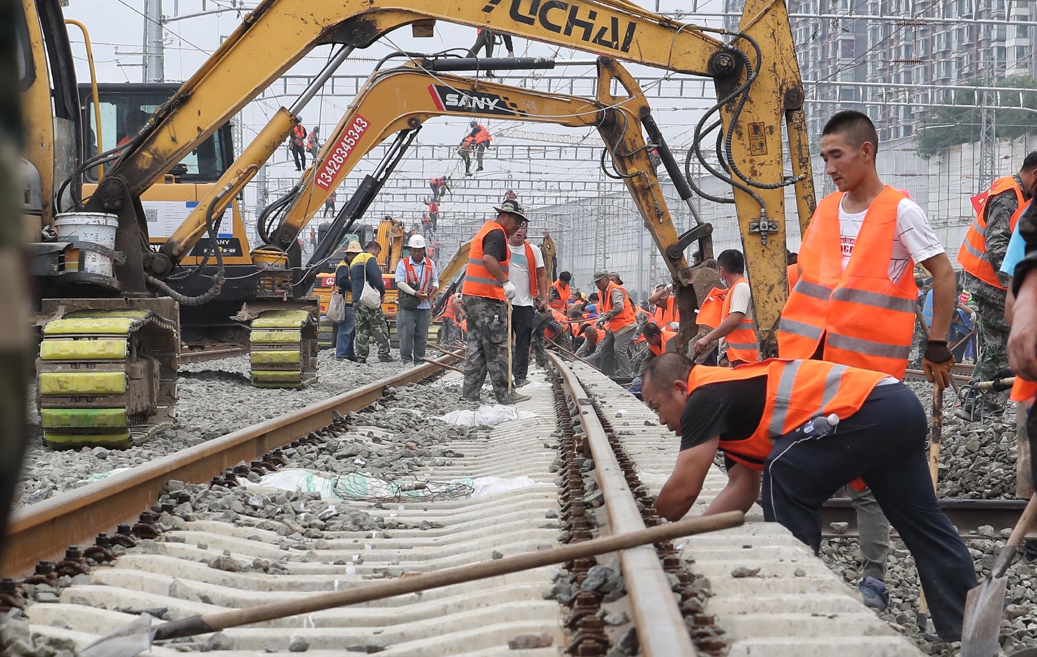 2020年8月30日,多台大型挖掘机辅助工人进行拨线作业.