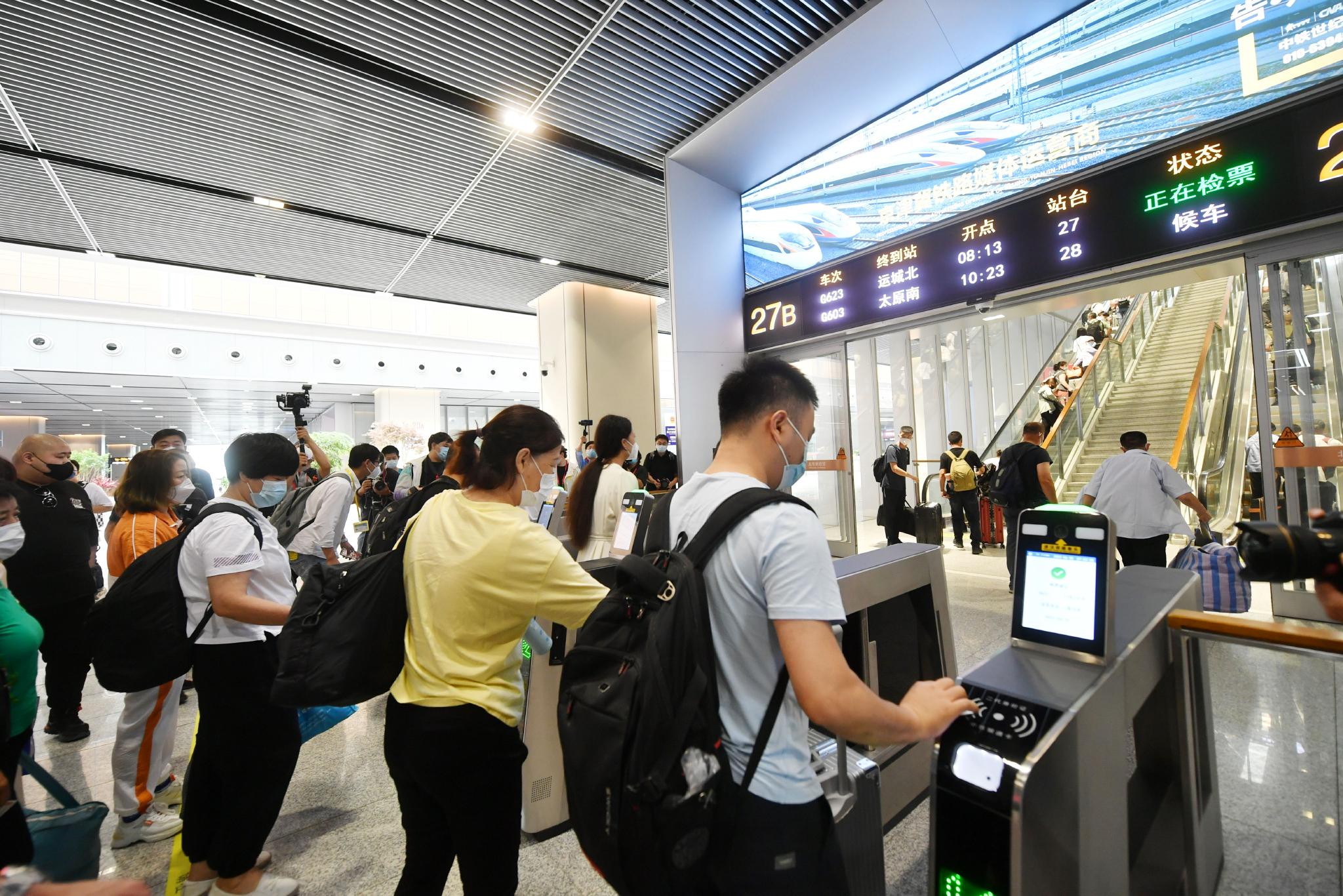 6月20日,北京丰台站,乘客检票进站.