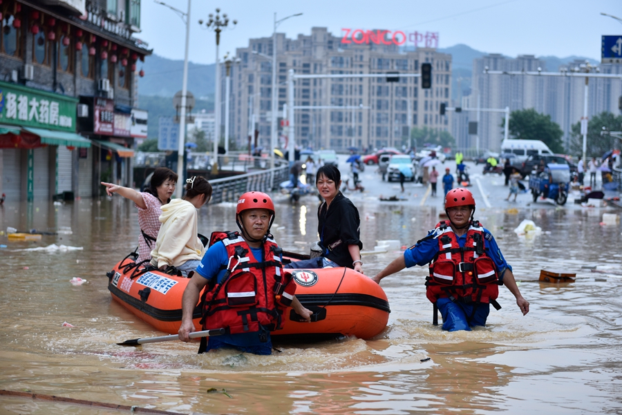 6月19日，在福建省建瓯市水南桥附近，蓝豹救援队利用橡皮艇转移被困群众。 （黄杰敏 摄）
