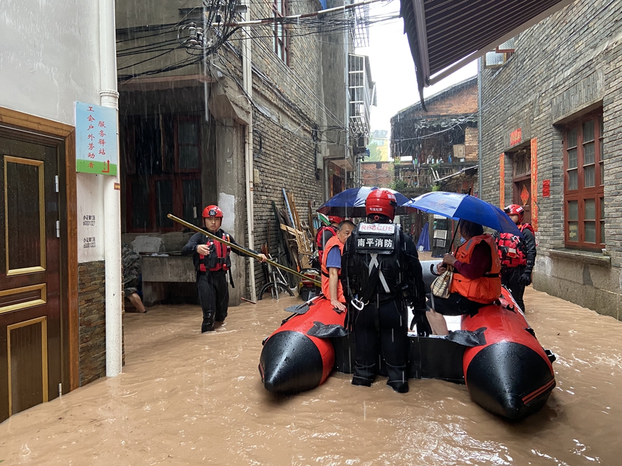 6月18日，消防救援人员在福建省松溪县古城路将被困老人转移至安全区域。 （南平市消防救援支队供图）