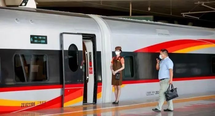 6月20日，武汉开往北京西的G66动车组列车乘务员正在迎接旅客上车。中新社记者 张畅 摄
