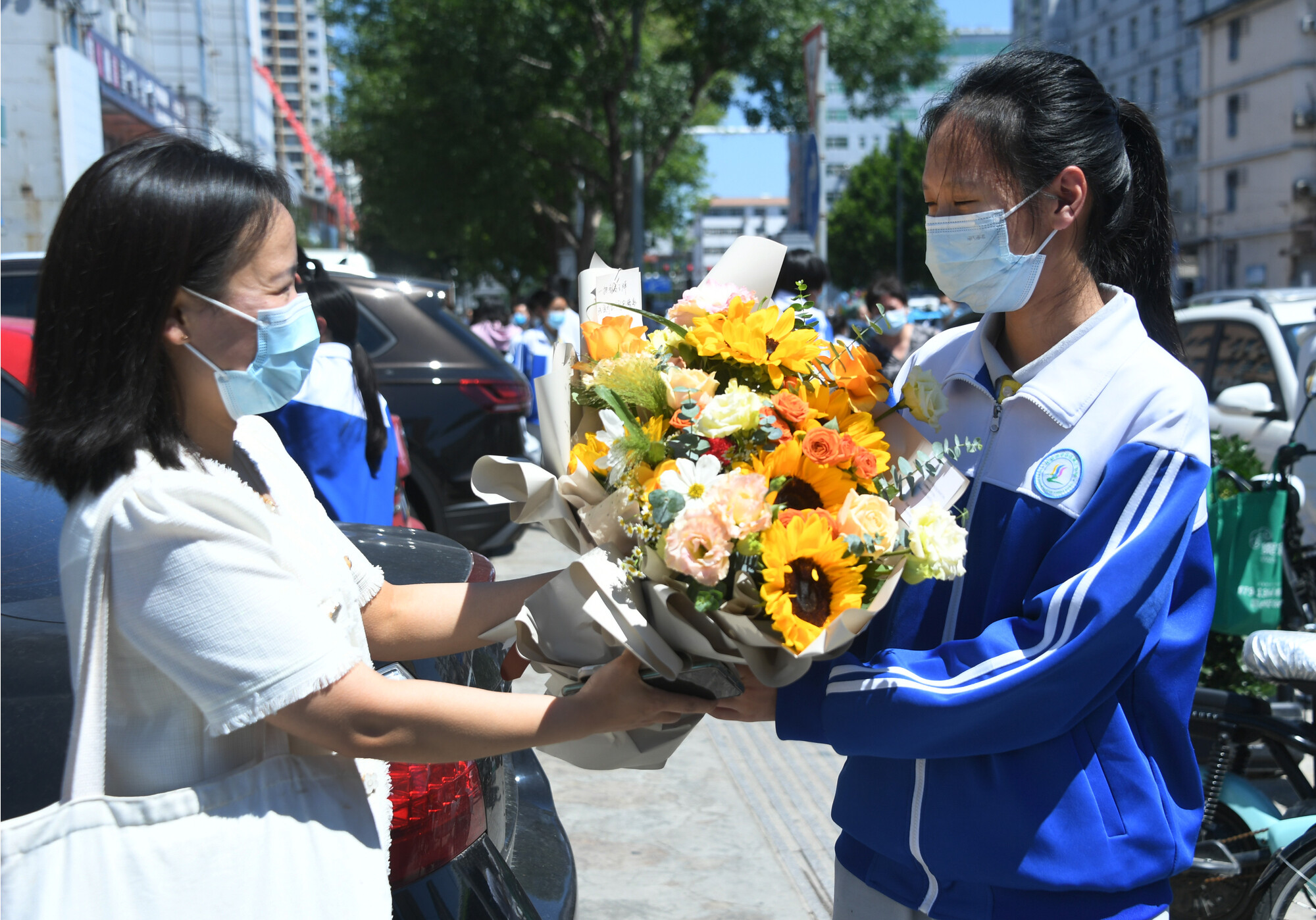 资料图 6月24日，考生在结束语文考试后走出北京市平谷区第三中学考点与老师（左一）交流。新华社发