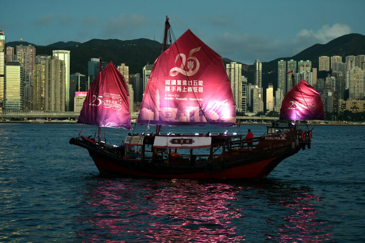 6月23日，一艘帆船挂上庆祝香港回归祖国25周年横幅在维港航行。新华社记者 卢炳辉 摄