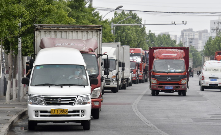 这是6月9日在北京丰台区一处货运中心外拍摄的等待运货的货车.
