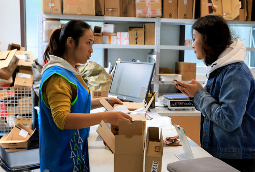 2019年11月13日,寄件员使用回收纸盒帮顾客包装需要快递的物品.