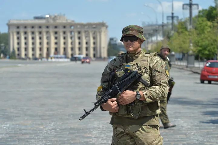 6月1日,乌克兰士兵在哈尔科夫市自由广场持枪警戒,远处为哈尔科夫州