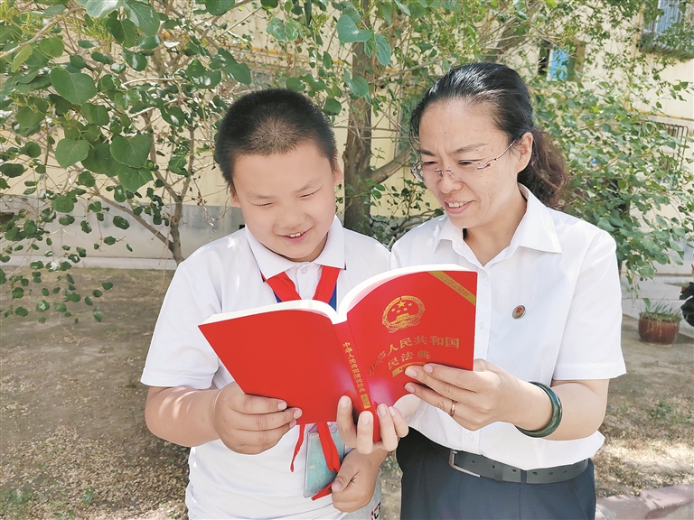 图③孙敬指导学生阅读《中华人民共和国民法典》（资料图片）。 孙敬 提供