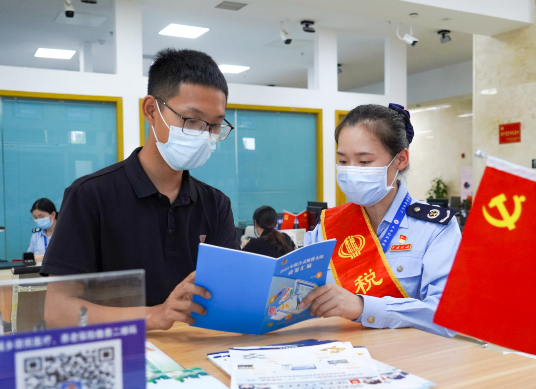 图为江西省抚州市东乡区税务局第一分局工作人员在为纳税人讲解增值税
