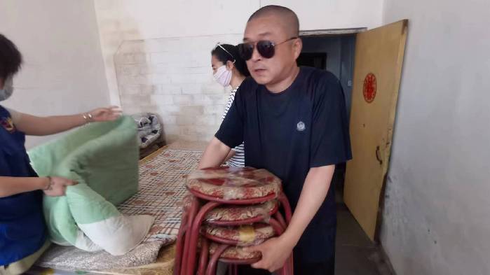 徐庆山帮忙把捐赠物品搬到米先生的出租屋内.