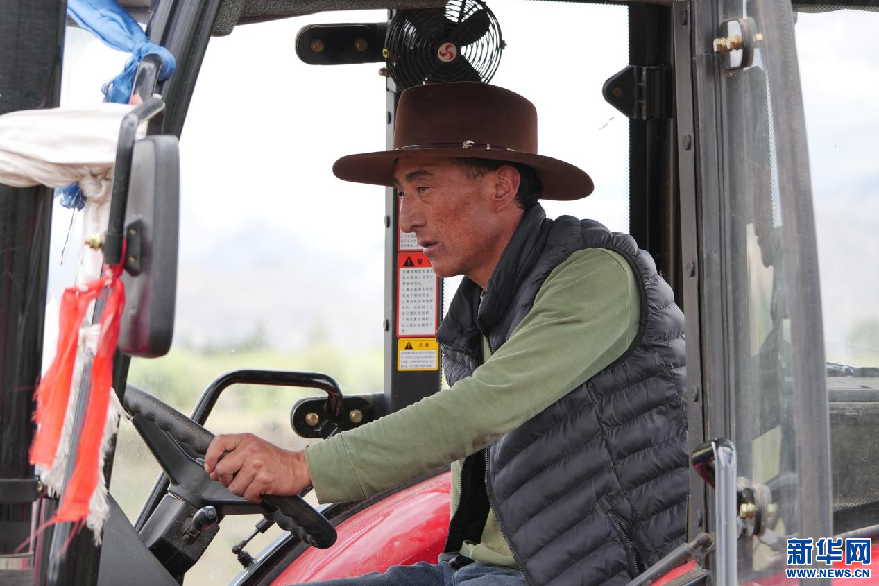 6月21日,在林周县强嘎乡曲嘎强村,农民驾驶农机进行播种.