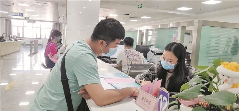 6月27日, 九师就业局工作人员(右)为前来咨询就业政策的人员讲解相关政策。 苟汇敏 摄