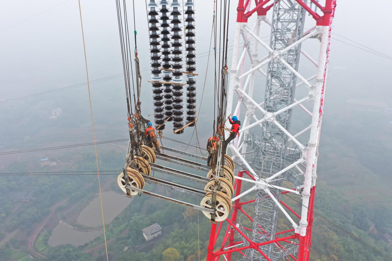 白江线重庆段施工人员在跨越塔上作业(刘伟摄)